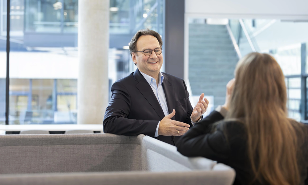 man with glasses being interviewed in business office