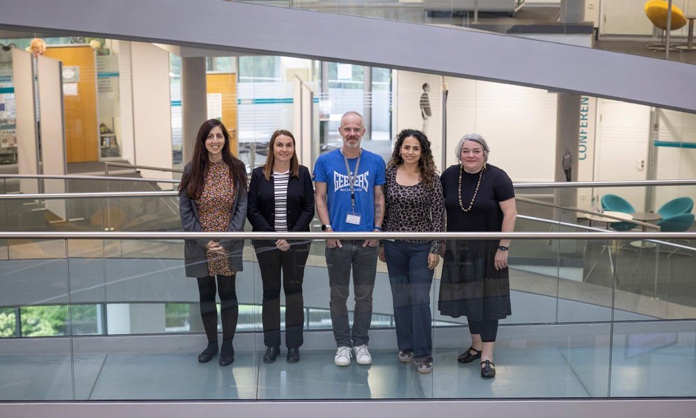 Five people are standing in line for the photo, representing EMBL, the company Merck, and the Universities of Freiburg and Cambridge
